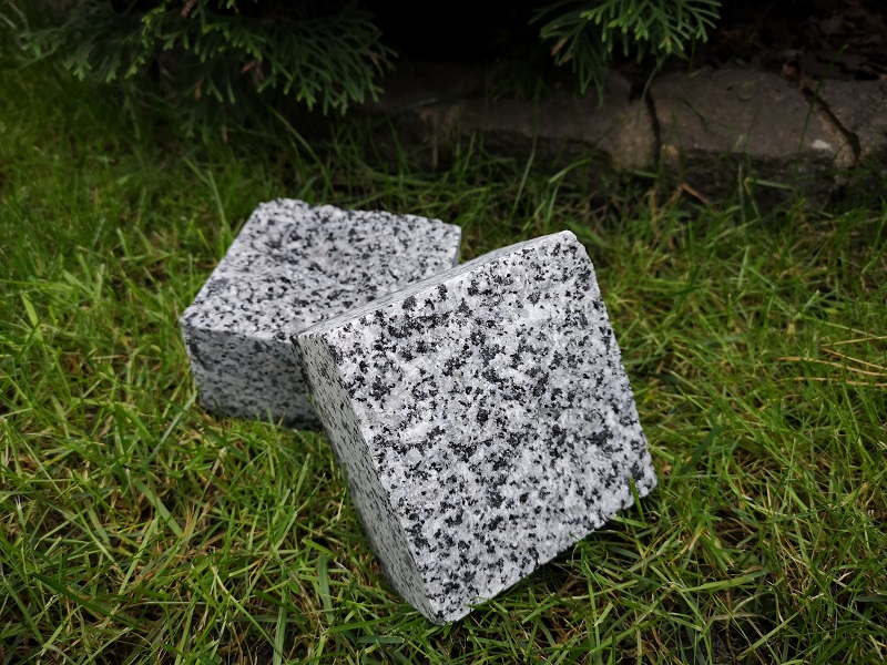 kostka granitowa leżąca na trawie